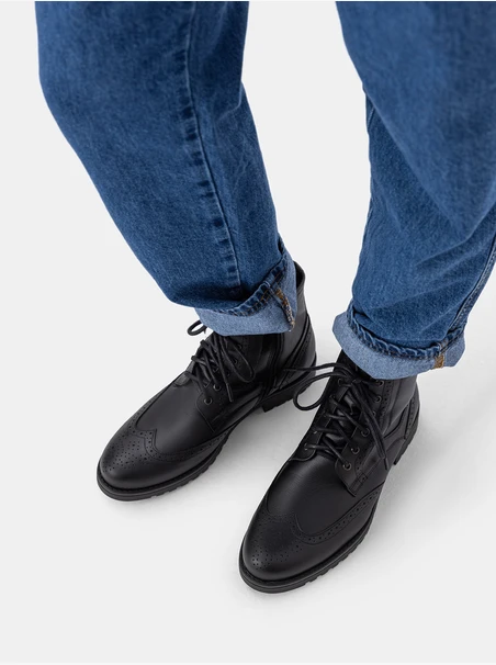 Schwarze Lederstiefel mit Perforationen